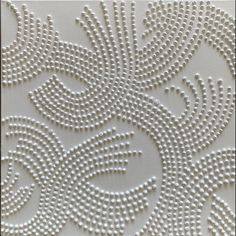 white beaded wallpaper with an intricate design on the front and back of it