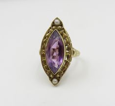 Originally $1,200.00 Circa 1900. Gorgeous Marquis Amethyst ring accented by pearls and beautiful engraving and open work detail in 14KT gold. A very elegant antique cocktail ring. The Bezel set Amethyst measures approximately 18mm x 8mm. The mounting/top of the ring, measures (point to point) approximately 28mm. The width of the mounting is approximately 11mm. The ring is a size 7 3/4 and can be sized. Customer Care: I will help guide you throughout the entire process of your ring selection. I o Antique 14k Gold Amethyst Ring, Fine Jewelry Amethyst Ring With Intricate Design, Elegant Gold Amethyst Ring With Intricate Design, Fine Jewelry Amethyst Ring With Intricate Design For Wedding, Heirloom Amethyst Ring With Intricate Design For Wedding, Intricate Design Amethyst Ring For Wedding, Heirloom Amethyst Wedding Ring With Intricate Design, Antique 14k Gold Pearl Wedding Ring, Antique Yellow Gold Pearl Ring