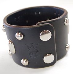 "This Beautiful black leather cuff is made using American bridle leather. I hand style the edges in a slightly distressed yet slick fashion and stud the top accordingly. Can be made in Beautiful brown Bridle leather as well! Custom sized for your wrist! Please use the instructions in the pics above! - 2- 1/8\" wide - Studded - American bridle leather Thanks! Freddie" Adjustable Black Wristband With Rivets, Punk Leather Cuff Wristband, Leather Punk Cuff Bracelet With Wrist Strap, Punk Leather Cuff Bracelet With Wrist Strap, Adjustable Leather Punk Wristband, Adjustable Black Cuff Bracelet With Rivets, Leather Cuff Bracelet With Rivets, Leather Cuff Bracelets With Custom Hardware, Adjustable Leather Punk Cuff Bracelet