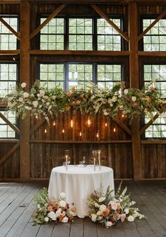 a table with flowers and candles on it in front of some wooden paneled walls