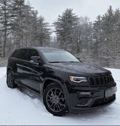 a black jeep is parked in the snow