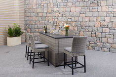 a table with four chairs next to a brick wall and potted plant on the side