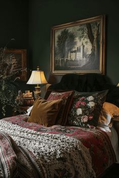 a bed in a room with green walls and paintings on the wall above it, along with two lamps