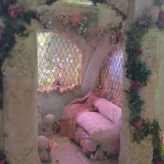 a room decorated in pink and white with flowers on the walls, windows, and curtains