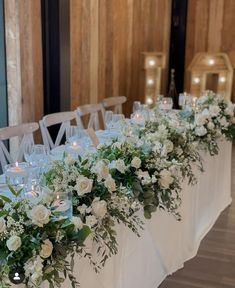 a long table with white flowers and candles