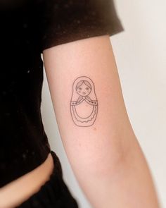 a woman's arm with a small tattoo of a girl holding a baby jesus