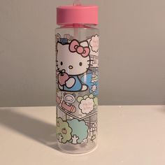 a hello kitty water bottle sitting on top of a white table next to a wall