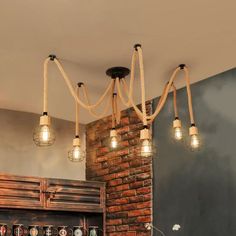 a brick wall with several lights hanging from it's sides and an open fire place in the middle