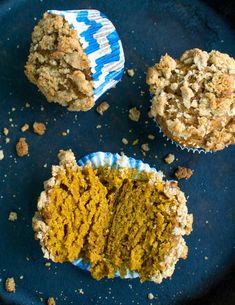 three muffins sitting on top of a blue plate covered in crumbs