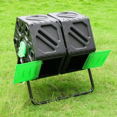 two black plastic bins sitting on top of a green metal stand in the grass