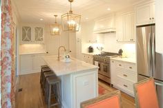 a kitchen with white cabinets and an island