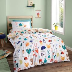 a child's bedroom with green walls and white bedding, featuring an animal themed comforter