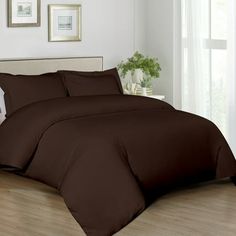 a bed with brown sheets and pillows in a room