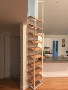 an open kitchen and living room with stairs leading to the upper floor, next to a dining area