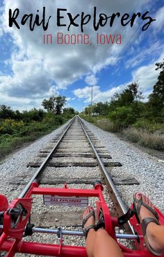 a person sitting on top of a red train track with the words rail explorers in boome, iowa