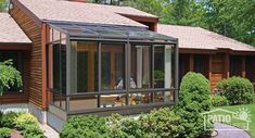 a house with a glass enclosed porch in the front yard