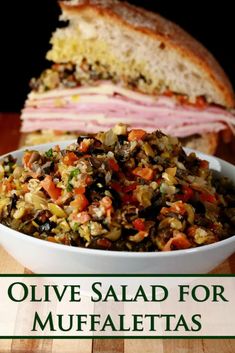 a close up of a bowl of food on a table with the words olive salad for muffalettas