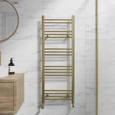 a bathroom with marble walls and flooring next to a gold towel rack on the wall