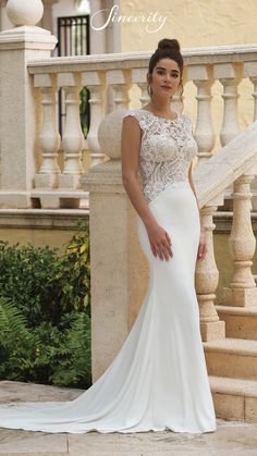 a woman in a wedding dress standing on stairs