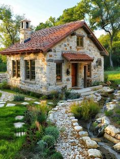 a small stone house with a stream running through it