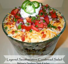 a glass bowl filled with mexican food on top of a table