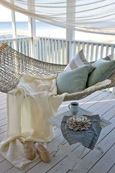 a hammock on a porch with pillows and blankets