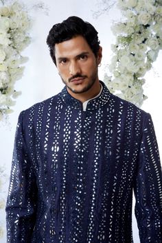 This midnight sherwani set features all over mirror work on a raw silk base. It is paired with an off-white cotton kurta and a afghani cotton silk salwar. Completing footwear is also available.From Seema Gujral's Tuscan Summer collection. DELIVERY TIMEPlease allow 4 months for your outfit to arrive.FABRIC DETAILSRaw SilkProfessional cleaning only. Designer Nehru Jacket With Mirror Work For Festive Season, Designer Nehru Jacket With Mirror Work For Eid, Designer Nehru Jacket With Mirror Work For Diwali, Designer Nehru Jacket With Mirror Work For Festivals, Designer Ceremonial Kurta With Mirror Work, Designer Kurta With Mirror Work For Festive Occasions, Designer Festive Kurta With Mirror Work, Designer Festive Kurta With Gota Work, Designer Gota Work Kurta For Diwali