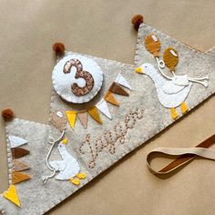 two felt pennants with birds and numbers on them