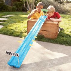 two young boys playing with a water slide