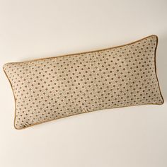 a brown and white polka dot pillow sitting on top of a wall