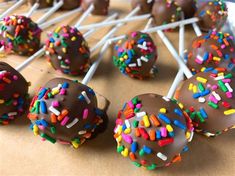 chocolate covered donuts with sprinkles are on a stick and ready to be eaten