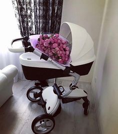 a stroller with flowers in it sitting on the floor