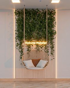 a hammock hanging from the ceiling in front of a wall with plants growing on it