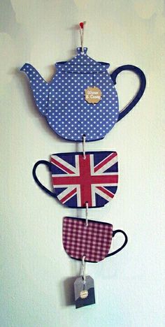 three teapots are hanging on the wall and one has a british flag in it