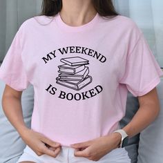 Packed with personality and perfect for the book lover, this My Weekend is Booked T-Shirt is the only way to show the world your passion for literature, and how the written page keeps you dedicated. Trust us, your weekends will never be dull again! -These classic fit t-shirts are not meant to be form-fitting, but rather offer a comfortable and relaxed style. If you prefer a more fitted look, we recommend sizing down one size. -Unisex sizing (Men and Women)-100% Cotton-The shirt brand that I use Bookish Short Sleeve T-shirt With Funny Text, Bookish T-shirt With Funny Print, Bookish T-shirt With Funny Print For School, Bookish T-shirt With Funny Text And Crew Neck, Bookish Letter Print T-shirt For School, School T-shirt With Letter Print In Bookish Style, Pink Crew Neck T-shirt With Bookish Style, Short Sleeve T-shirt With Funny Text, Not Meant To Be