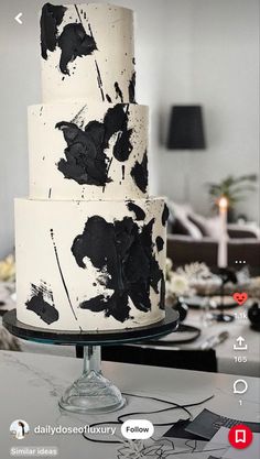 a black and white cake sitting on top of a table next to a couple of candles