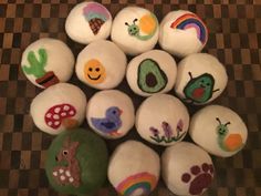 several balls with painted animals on them sitting on a checkered tablecloth covered floor