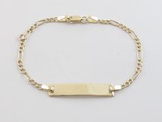 "Baby ID Name Figaro Bracelet Gold 14k Yellow and white Gold. Perfect gift to a baby. This beautiful and stylish bracelet is great for both Birthday or baby shower. Surprise your loved ones with this unique bracelet and create the best memories together! Metal purity: Real 14k Gold , Stamped on the clasp Length: 6\" long Width: 1/4\" or 5.0 mm wide on the ID and 3.0 mm wide on the Links Weight: 2.30 grams Links finish: Shiny yellow Closure: Lobster clasp Engraving is done in Capital , script and Personalized 14k Gold Bracelet For Birthday, Yellow Gold Nameplate Bracelet For Birthday, 14k Gold Bracelet For Birthday, 14k Gold Name Bracelet For Birthday, Yellow Gold Rectangular Name Bracelet As Gift, Adjustable 14k Gold Bracelet For Birthday, 14k Yellow Gold Hallmarked Name Bracelet, 14k Yellow Gold Bracelets For Birthday, Personalized Yellow Gold Bracelet For Birthday