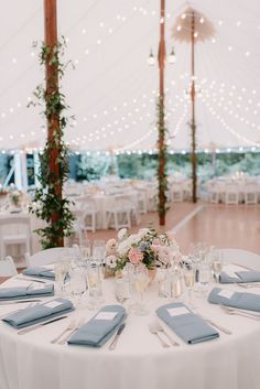 a white table topped with blue napkins and plates