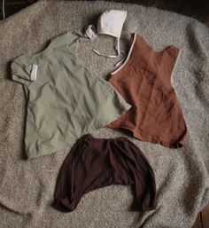 three different types of clothing laying on top of a bed next to each other,