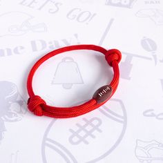 a red bracelet with a bell charm on it