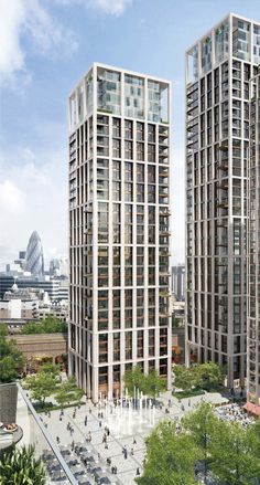 two tall buildings next to each other on a city street with lots of trees in front of them