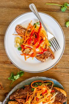 two plates filled with food on top of a wooden table next to a fork and knife