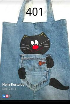 a black cat is sticking its head out of a pocket in a denim tote bag