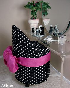 a black and white polka dot hat sitting on top of a table next to a mirror