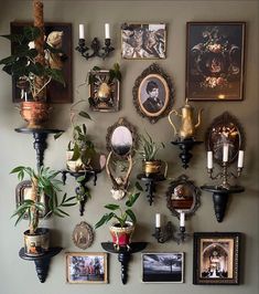 there are many pictures on the wall with candles and plants in vases next to them