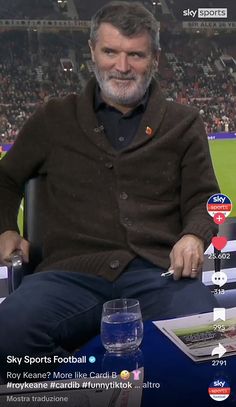 a man sitting in a chair on top of a tv screen with the sky sports football logo