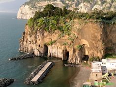 an aerial view of the beach and cliffs in front of a cliff with houses on it