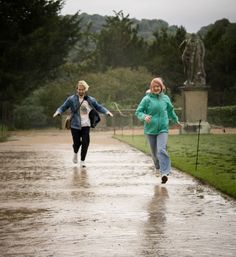 two women running in the rain with umbrellas