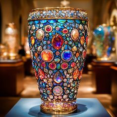 a colorful vase sitting on top of a table next to other glass items in a room